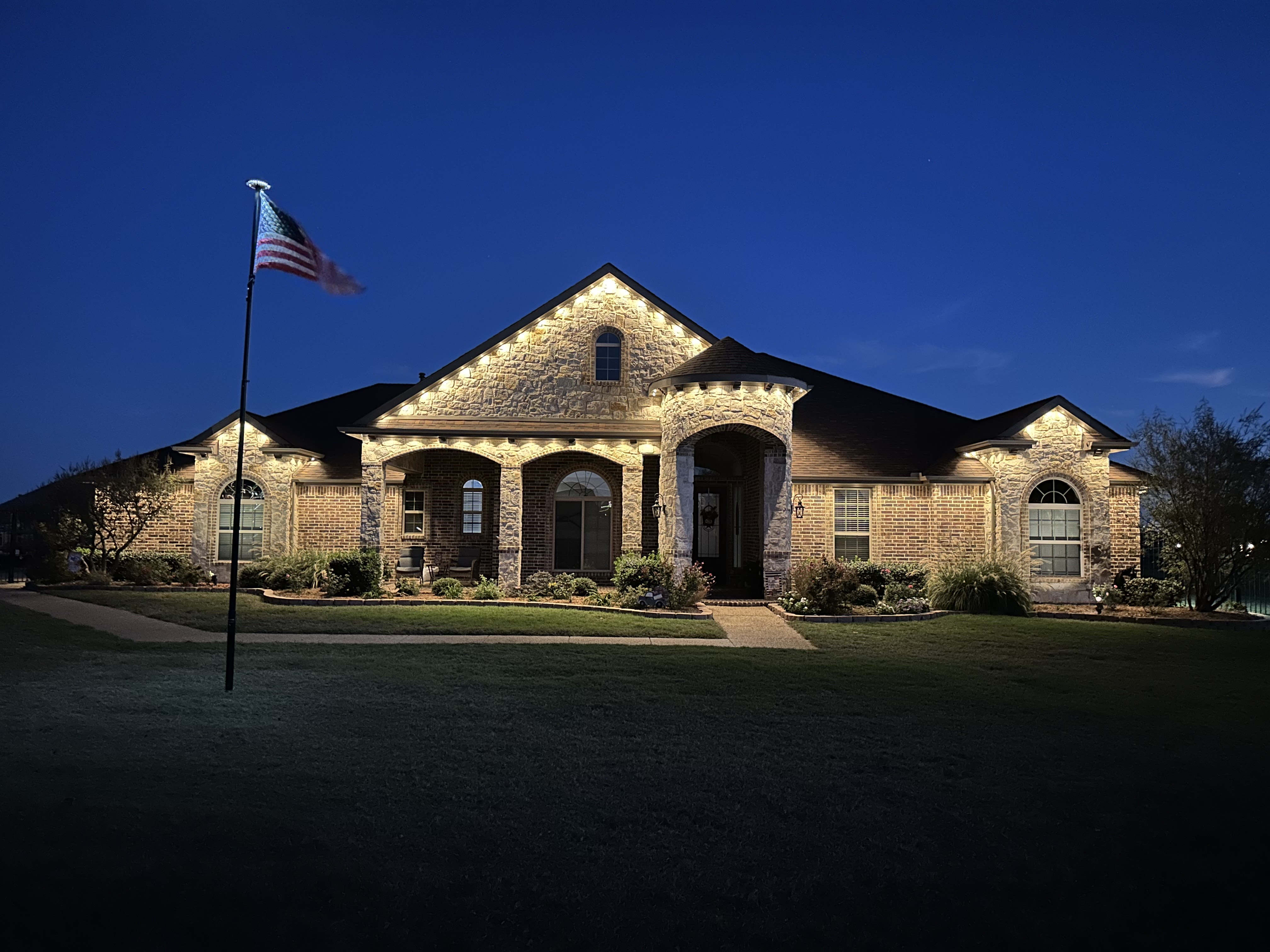 DFW LED system with large bright LEDs illuminating entire property including home facade, landscaping, and walkways