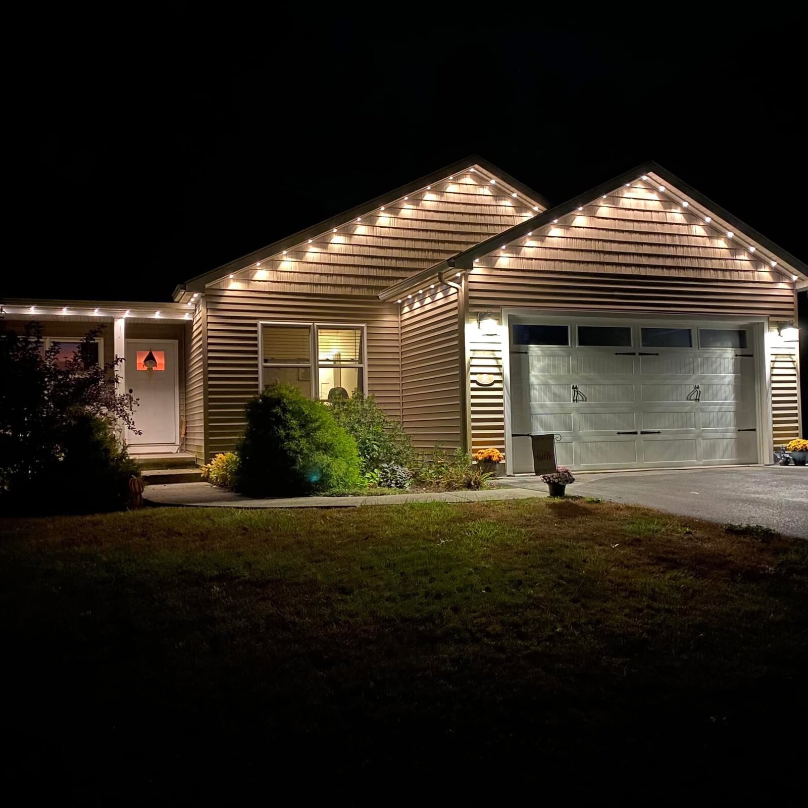 Warm white permanent eave lighting on a single-story home